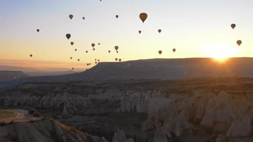 Hot Air Balloons Over Desert Landscape at Sunrise