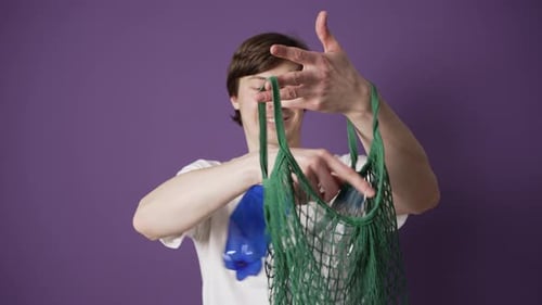 Joven anima a la gente a reciclar botellas de plástico