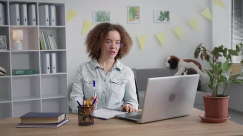 Woman Working on Laptop and Taking Notes