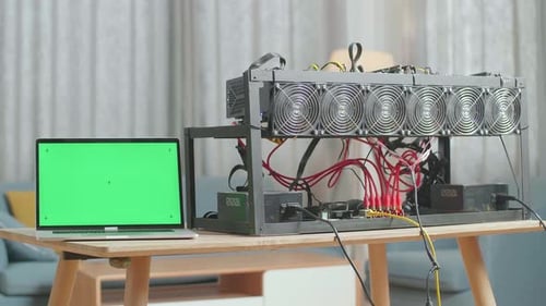 A Green Screen Laptop Is On The Table With Cryptocurrency Mining