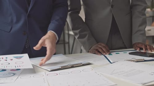 Businessmen Analyzing Charts in Modern Office