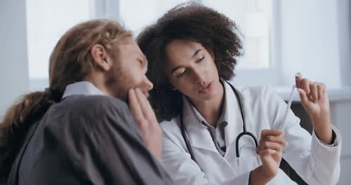 Doctor Shows X-Ray to Patient in Office