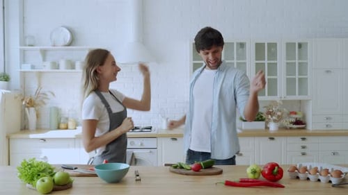 Couple Joyfully Dancing Together in a Bright Kitchen
