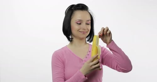 Woman Peels and Bites a Banana