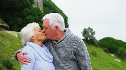 Loving Elderly Couple Embracing and Kissing Outdoors