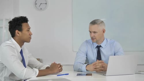 Mixed Race Businessmen Discussing Project in Office