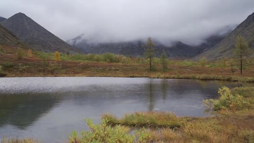 Thick Clouds Float Low Over the Mountain Lake