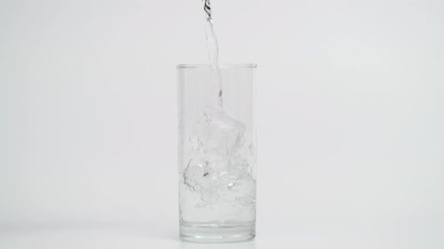 Water Being Poured Into Glass on White Background