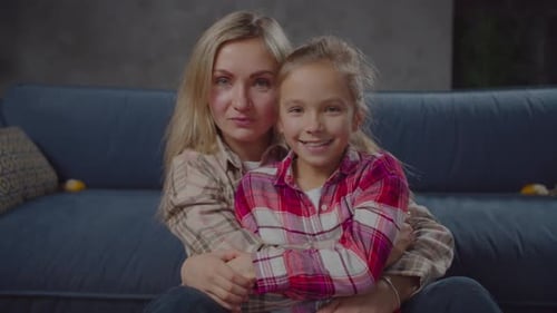 Mother and Daughter Embracing and Kissing Indoors