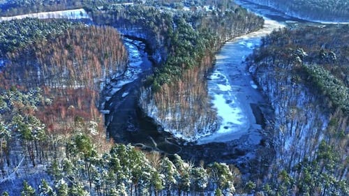 Gefrorener Fluss und Wald im Winter. Luftbild der Natur