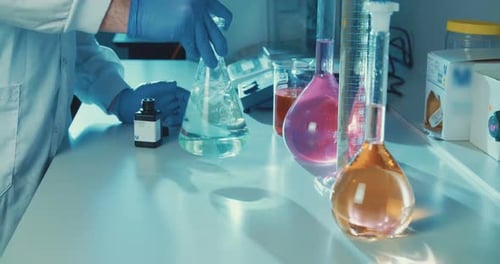 Scientist mixing liquid in laboratory flask