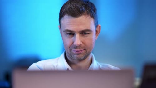 Nahaufnahme Porträt eines gutaussehenden selbstbewussten kaukasischen Mannes mit Laptop, der in die Kamera blickt