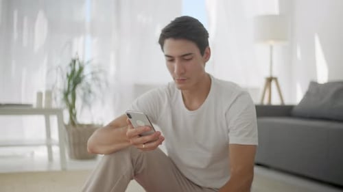 Young Adult Using Phone and Drinking Water Indoors