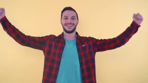 Excited Young Man Celebrating Success with Arm Raise