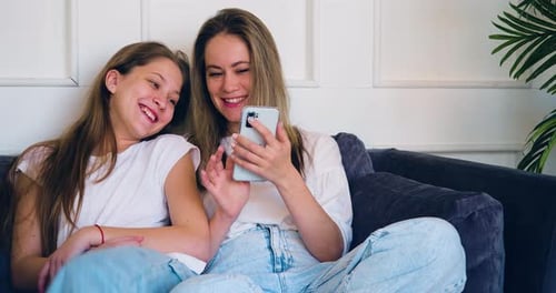 Child and Adult Relaxing Together with Smartphone
