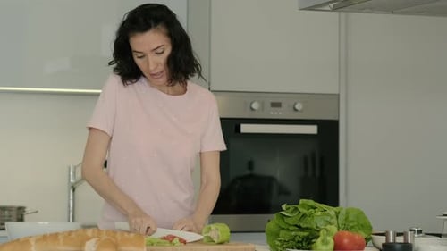 Woman Chopping Vegetables and Smiling in Kitchen