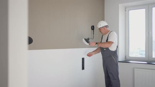 Man Installing Lighting Fixture in New Apartment