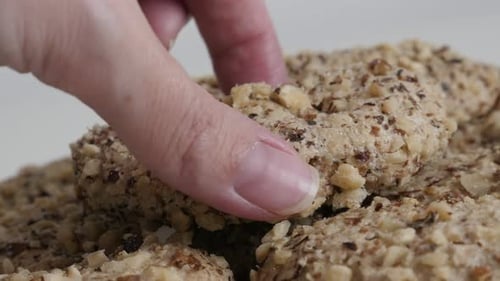 Hand Taking Nut Covered Cookie Close Up