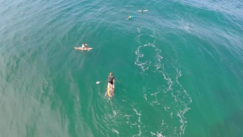 Aerial view of two men sup stand-up paddleboard surfing in Hawaii