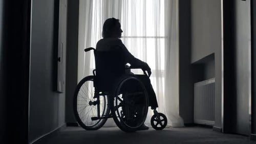 Silhouette of Person in Wheelchair by Window