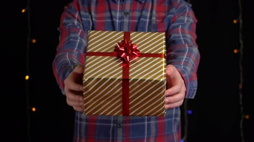 Close Up of Holiday Gift Presented by Man