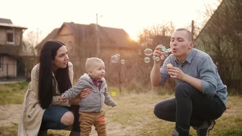 Family Enjoys Blowing Bubbles Together Outdoors