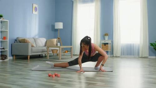Athletic Woman Stretching on Yoga Mat in Bright Room