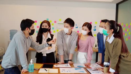 Team Discussing Business Wearing Facemasks at Workplace