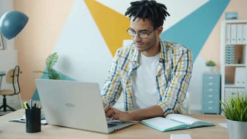 Young Afro-American Businessman Working with Laptop Computer in Office Alone