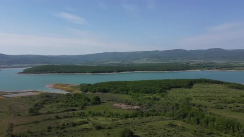 Aerial View on Water Reservoir at Mountain Valley Covered with Green Spring Forest
