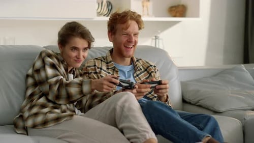 Couple Playing Video Games Together on Couch at Home