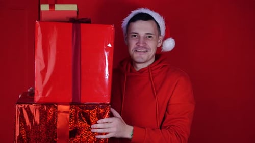 Festive Man Smiling Holding Christmas Gifts