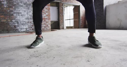 African american man exercising with medicine ball in an empty urban building