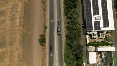 Tow truck carrying a single car on a rural highway, Aerial follow footage.