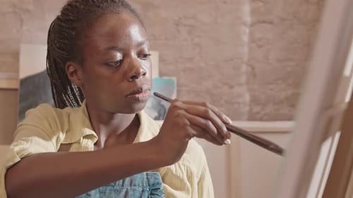Female Artist Painting in Sunny Studio