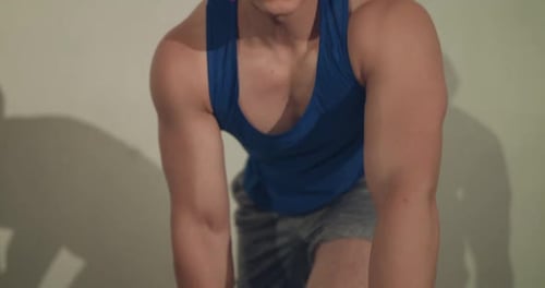 Strong Athlete Training Arm Muscles with Dumbbell at Camera in the Gym