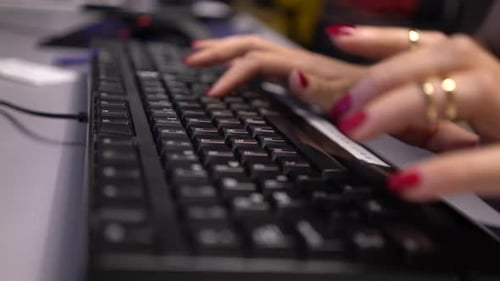 Woman Typing on a Black Computer Keyboard