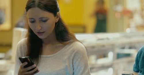 Brunette Woman Using Smartphone In Cafe