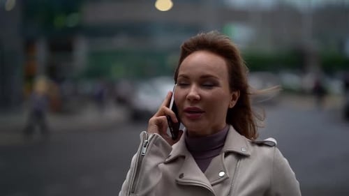 A Sad Young Woman I See Talking on a Mobile Phone While Standing on the Street.