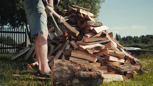 Strong Male Worker Chopping Wood Swinging and Hitting Wooden Log with Axe