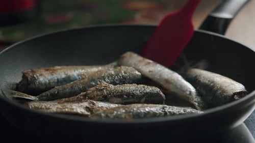 Frying Fresh Fish in a Pan on a Stove