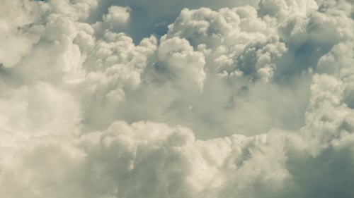 Fluffy White Clouds Drifting Across a Blue Sky