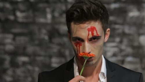 Man with Horror Makeup Holds Orange Flower