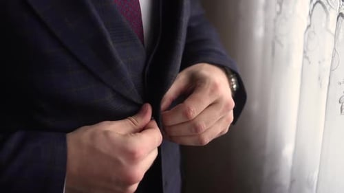 Man Fastening Suit Jacket Buttons, Close-Up
