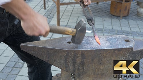 Blacksmith Shaping Red Hot Metal with Hammer