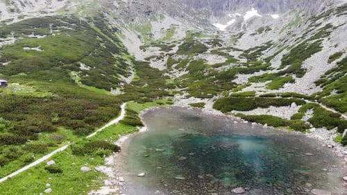 AERIAL: Flying Over the Crystal Clear Mountain Lake in Slovakia