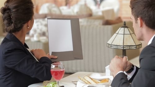 Businesswoman Presents to Businessman at Upscale Restaurant