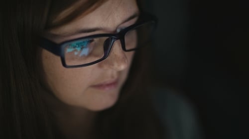 Woman with Glasses Works at Computer at Night