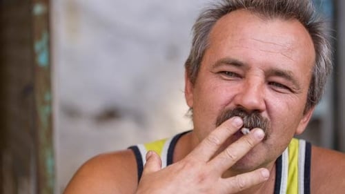 Homme qui fume avec des moustaches