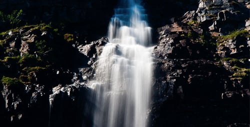 Picturesque Waterfall Flowing Over Rocky Cliffside